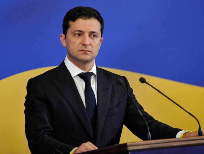 1448861675 featured image Man in suit speaking at podium with microphones
