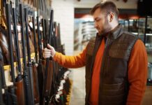 Man examining rifles in a store