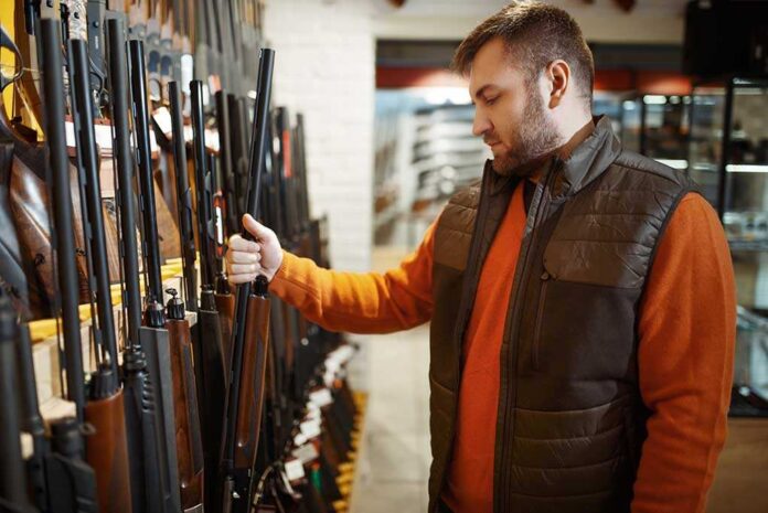 1668329110 featured image Man examining rifles in a store