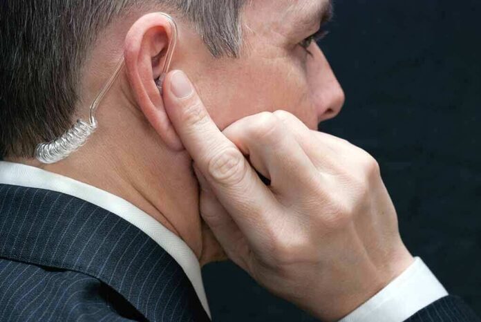 172646540 featured image Man wearing an earpiece, touching his ear