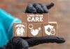 Gloved hand holding longterm care wooden blocks