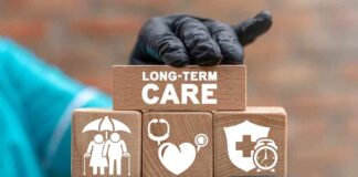 Gloved hand holding longterm care wooden blocks
