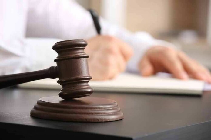 2454469737 featured image Judge's gavel on desk with person writing