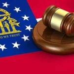 Georgia flag and judge's gavel on wooden base