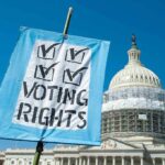 Sign reading Voting Rights in front of Capitol building
