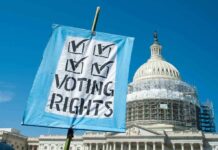 Sign reading Voting Rights in front of Capitol building