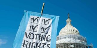 Sign reading Voting Rights in front of Capitol building