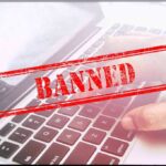 Red Banned stamp over a laptop keyboard
