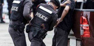Police officers arresting a handcuffed person
