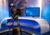 TV studio with camera and empty anchor desk