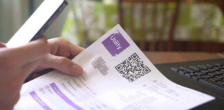 Hand holding utility bill with QR code