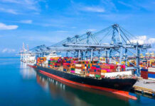 Container ship docked at a busy industrial port