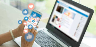 Person using smartphone and laptop with social media icons