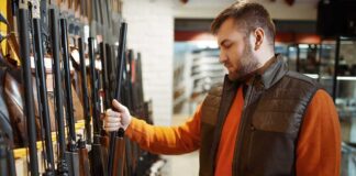Man examining rifles in a store