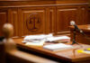 Wooden courtroom desk with papers and a microphone
