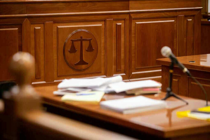 1812892960 Wooden courtroom desk with papers and a microphone