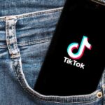 Phone with TikTok logo in jeans pocket