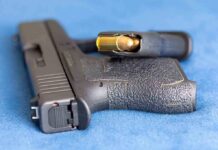 Handgun on blue fabric with visible bullet cartridge