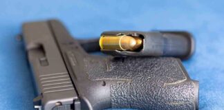 Handgun on blue fabric with visible bullet cartridge