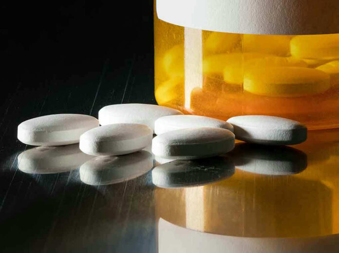 White pills beside an orange pill bottle