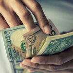 Person holding multiple bills