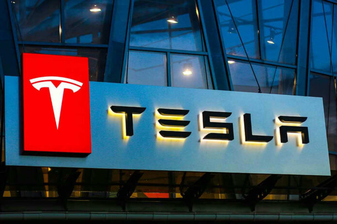 1140629366 Tesla logo on a building at night.