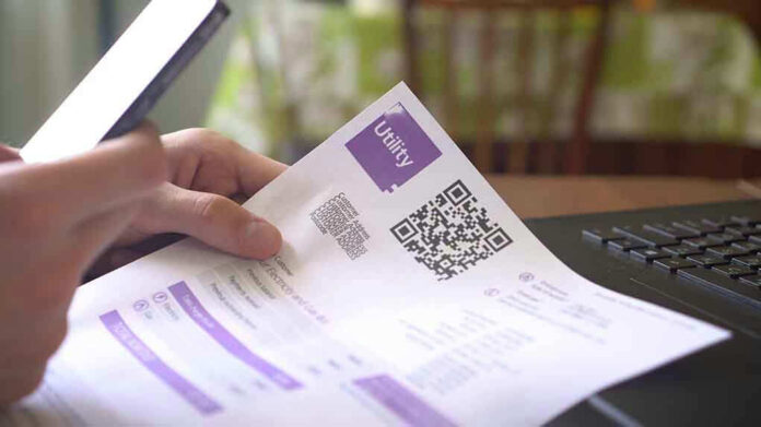 1414472381 Hand holding utility bill with QR code