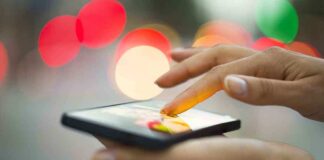 A person using a smartphone with a colorful bokeh background