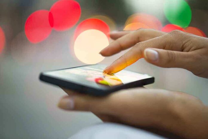 A person using a smartphone with a colorful bokeh background