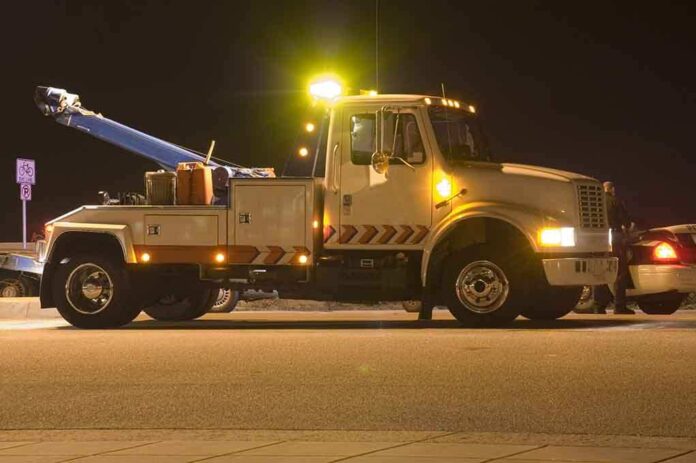 shutterstock_2638128.jpg Tow truck with flashing lights parked at night
