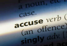 Close-up dictionary definition of accuse underlined.