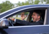 Man yelling inside a car, looking frustrated.
