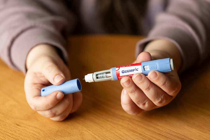2349255139 Hands holding an Ozempic injection pen.