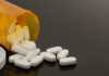 Spilled prescription bottle with white pills.