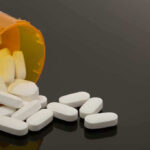 Spilled prescription bottle with white pills.