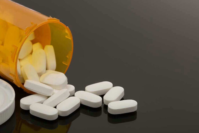 Spilled prescription bottle with white pills.