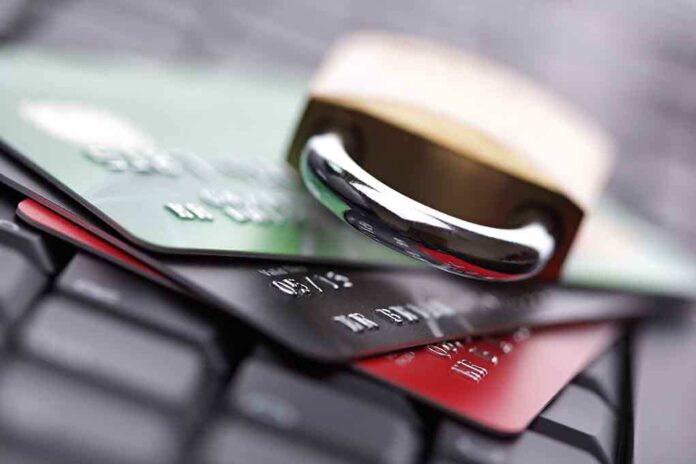 A padlock resting on top of multiple credit cards on a keyboard