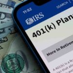 Mobile phone displaying IRS information about 401(k) plans on a background of cash