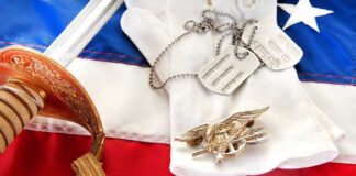 Military items including a sword, gloves, dog tags, and an American flag