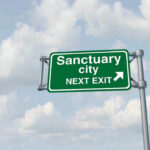 Sanctuary Laws Shield KILLER — County Leader DEAD Green road sign saying sanctuary city next exit