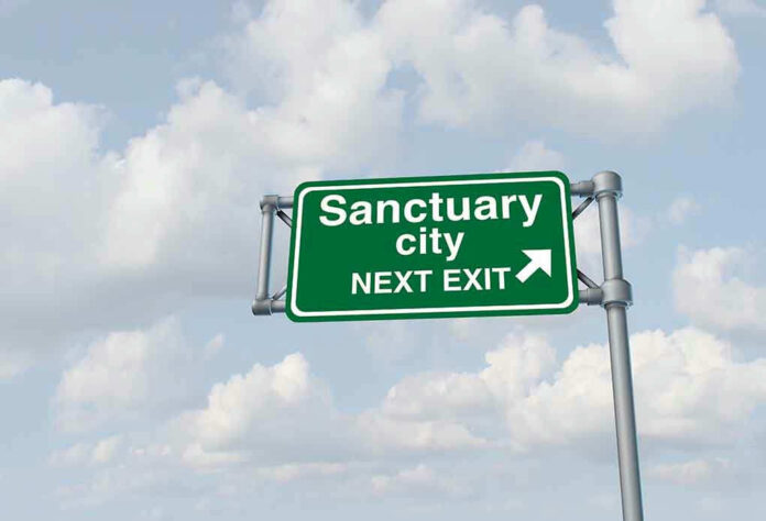 1031290987 Green road sign saying sanctuary city next exit