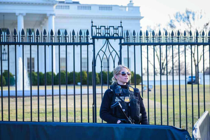 1435108799 Secret Service agent stands guard outside the White House.