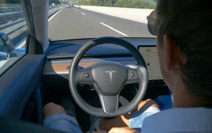 172510537 Person using autopilot in Tesla on highway.