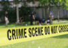 Yellow crime scene tape blocking grassy area.