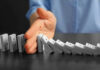 Troop Emergency Pay BLOCKED—Senate Stuns Military Hand stopping falling row of dominoes.
