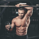 Muscular man in gym holding a shaker bottle