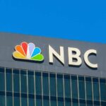 NBC logo displayed on a corporate building against a blue sky
