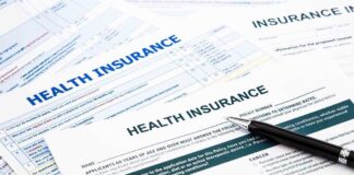 Close-up of health insurance application forms with a pen