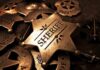 A collection of vintage sheriff badges arranged on a dark surface