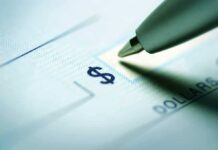 Billionaire SAVES Troops When Government FAILS Close-up of a pen poised over a check with a dollar sign